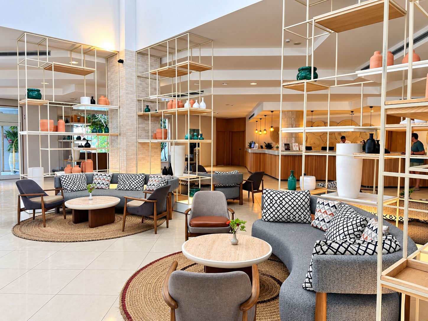 En rummelig lobby med siddepladser, en receptionsdisk og reoler med dekorative genstande.