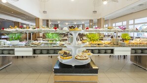 A buffet with various desserts and a central display of cakes.