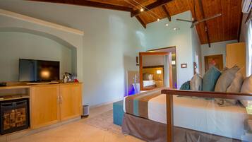 Une chambre d’hôtel avec un plafond en bois, une télévision, un canapé et un lit.
