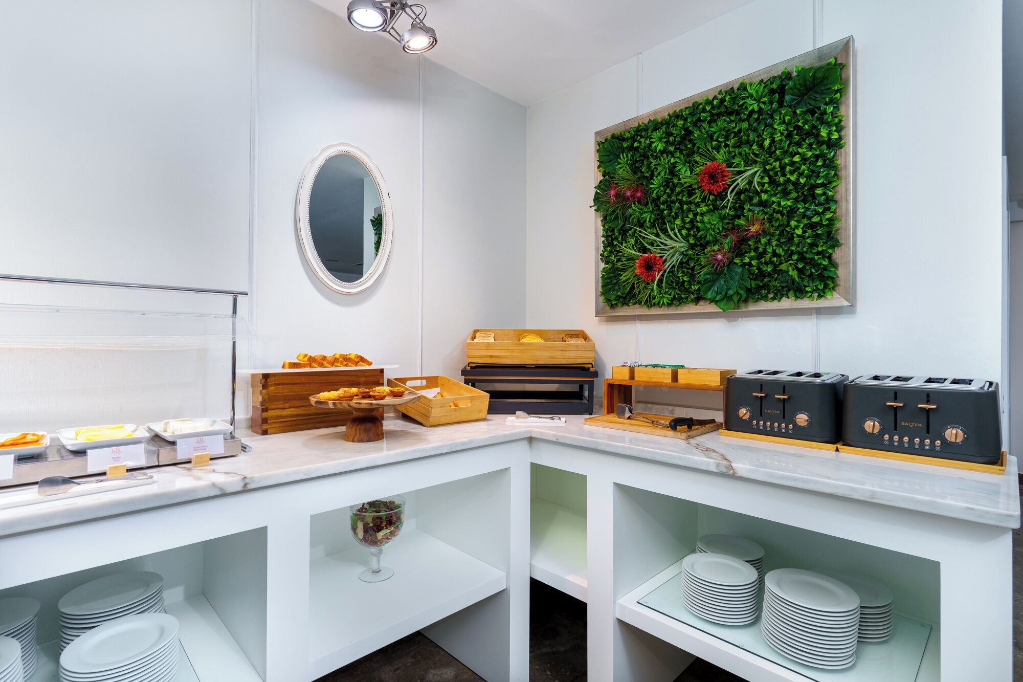 A kitchen counter with a mirror, a green wall decoration, and a toaster.
