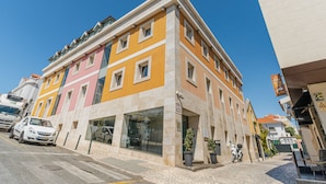 Un edificio de varios pisos con una tienda en la planta baja y un estacionamiento.