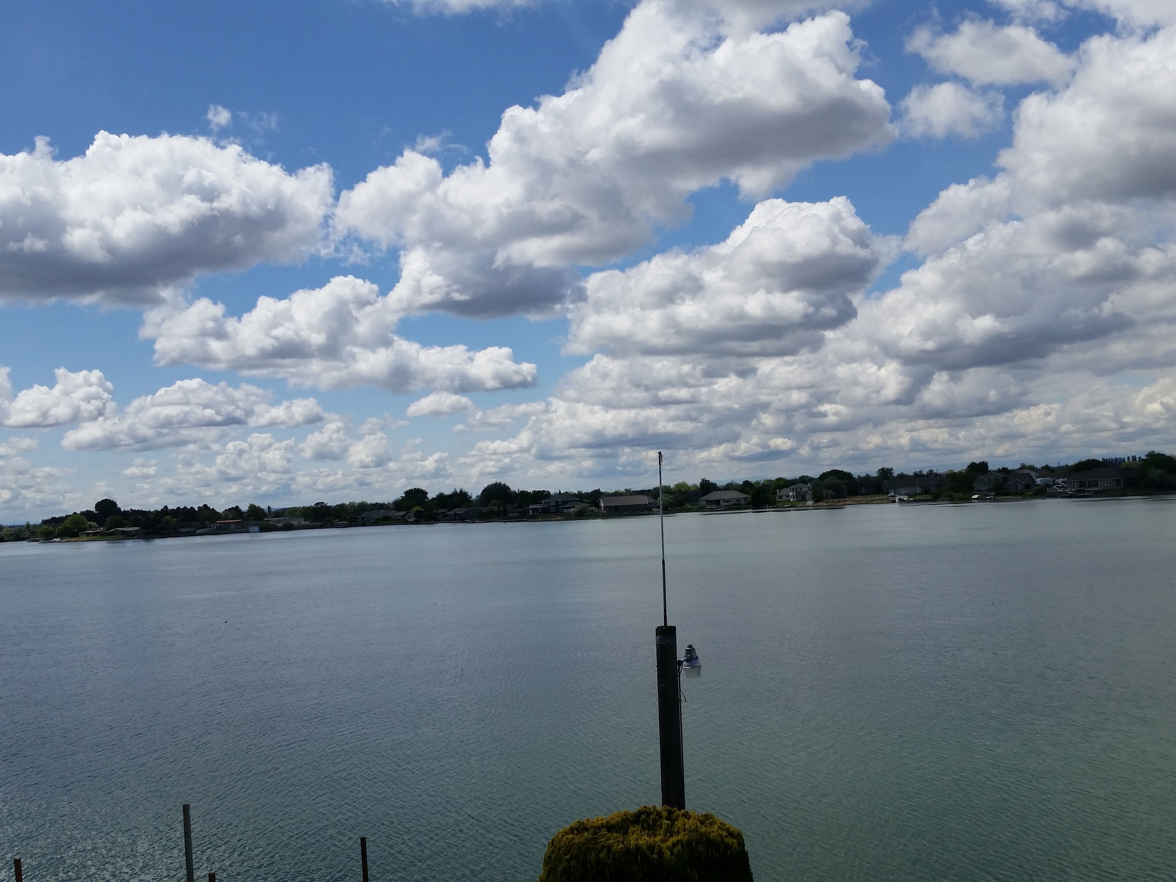 Un lac paisible, sous un ciel dégagé parsemé de quelques nuages.