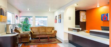 A hotel reception area with a sofa, a coffee table, and a reception desk.