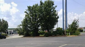A parking lot with marked parking spaces and a gas station in the background. - Stay 4 Less (Fredericksburg)