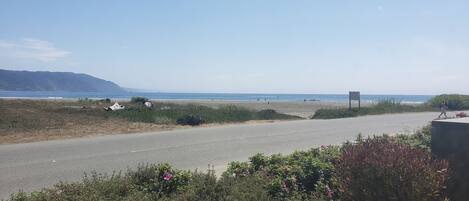 A coastal road with a clear view of the beach and ocean.