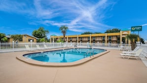 A hotel with a swimming pool, white lounge chairs, and a fenced area. - Quality Inn White Springs Suwanee (White Springs)