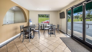 A hotel lobby with a dining area, a reception desk, and a view of the outside. - Quality Inn White Springs Suwanee (White Springs)