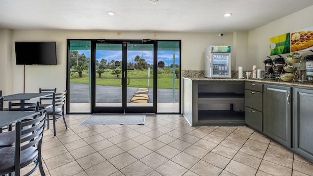 A modern kitchen with a large window, a flat-screen TV, and a coffee machine. - Quality Inn White Springs Suwanee (White Springs)