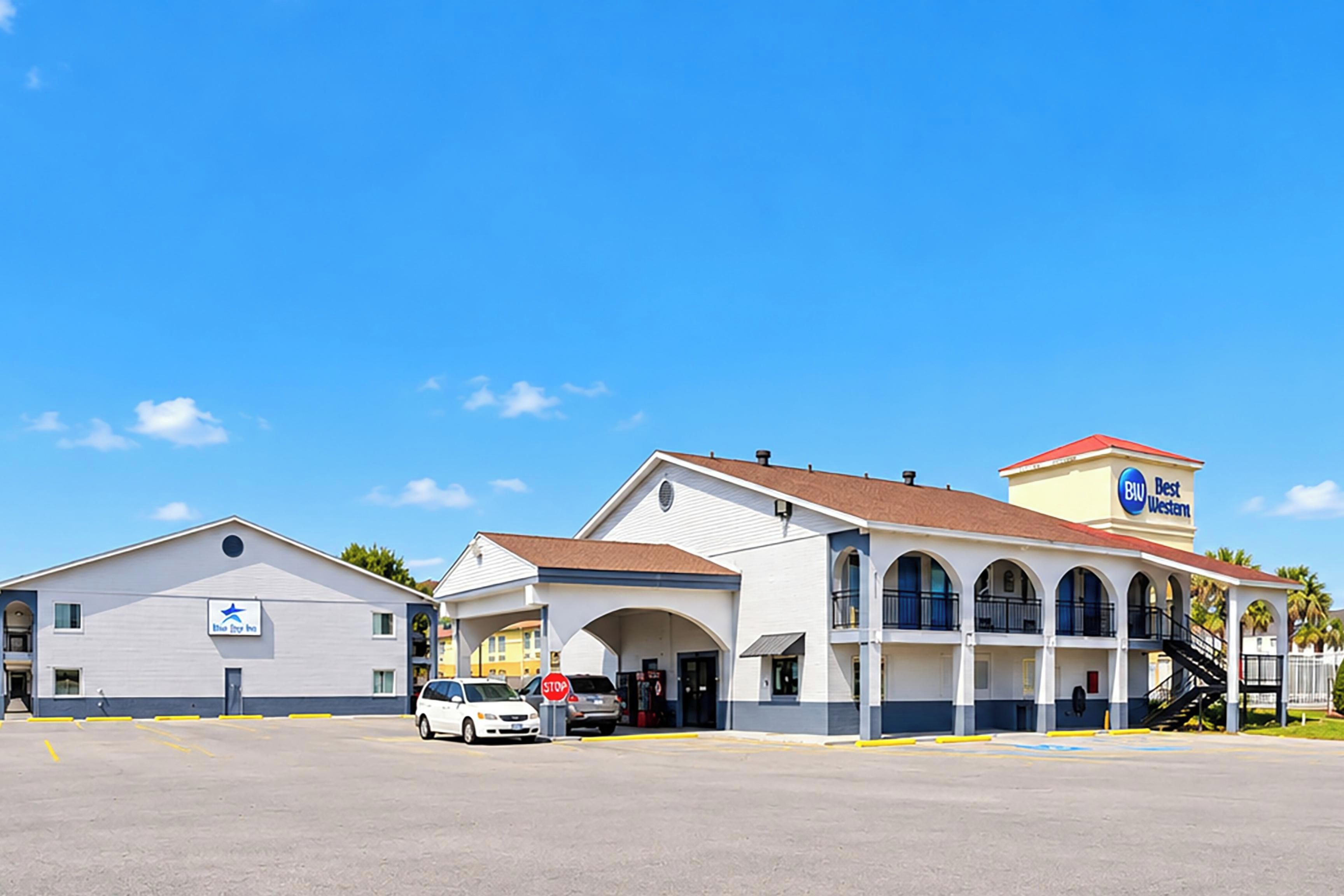 Un hotel de dos pisos, con acceso cubierto y estacionamiento.