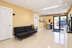 A reception area with a sofa, a refrigerator, a plant, and a door marked 'PRIVATE'. - Blue Star Inn Lafayette Near Airport I-10 (Lafayette)