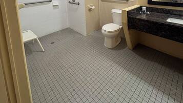 A bathroom with a shower, toilet, and sink.