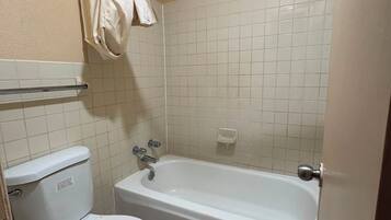 A bathroom with a toilet, a bathtub, and a towel rack.
