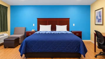 Une chambre d’hôtel avec un grand lit, un bureau, une chaise, une table de chevet et un radiateur fixé au mur.