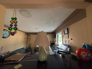 A room with a desk, a lamp, a clock, and a bottle of Tide PODS. - Blue Star Inn Lafayette Near Airport I-10 (Lafayette)
