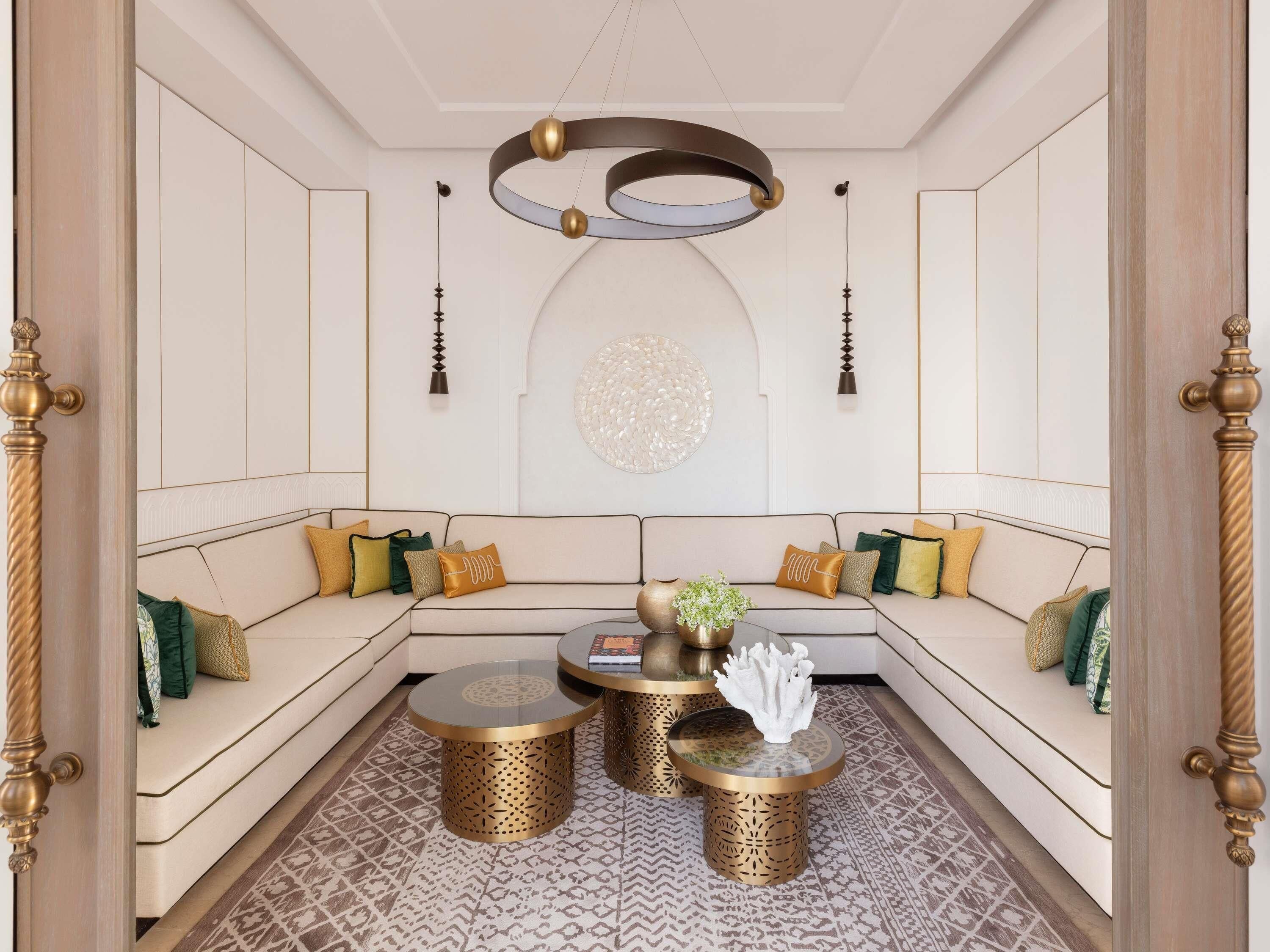 Una sala de estar moderna con un sofá modular, lámparas decorativas y alfombras estampadas.