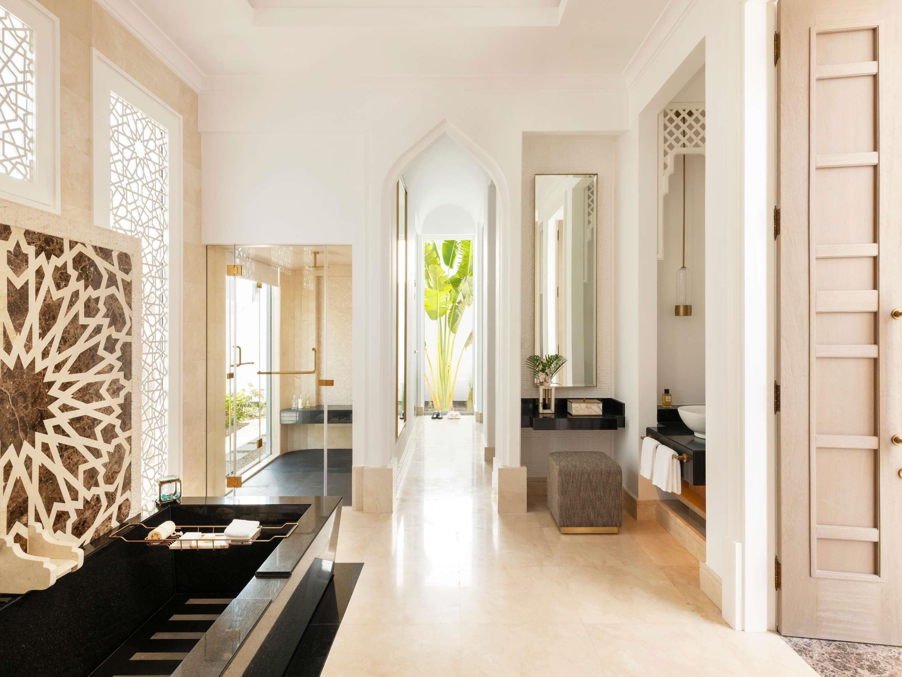 A modern bathroom with a black sink, a mirror, and a towel rack.