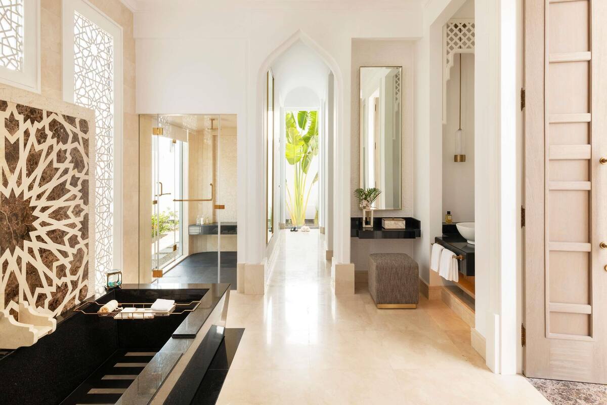 A modern bathroom with a black sink, a mirror, and a towel rack.