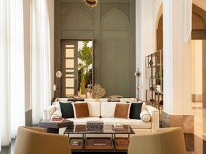 A modern living room with a sofa, coffee table, and books. - Raffles Al Areen Palace Bahrain (Zallaq)