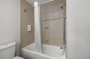 Un baño con bañera, ducha e inodoro.