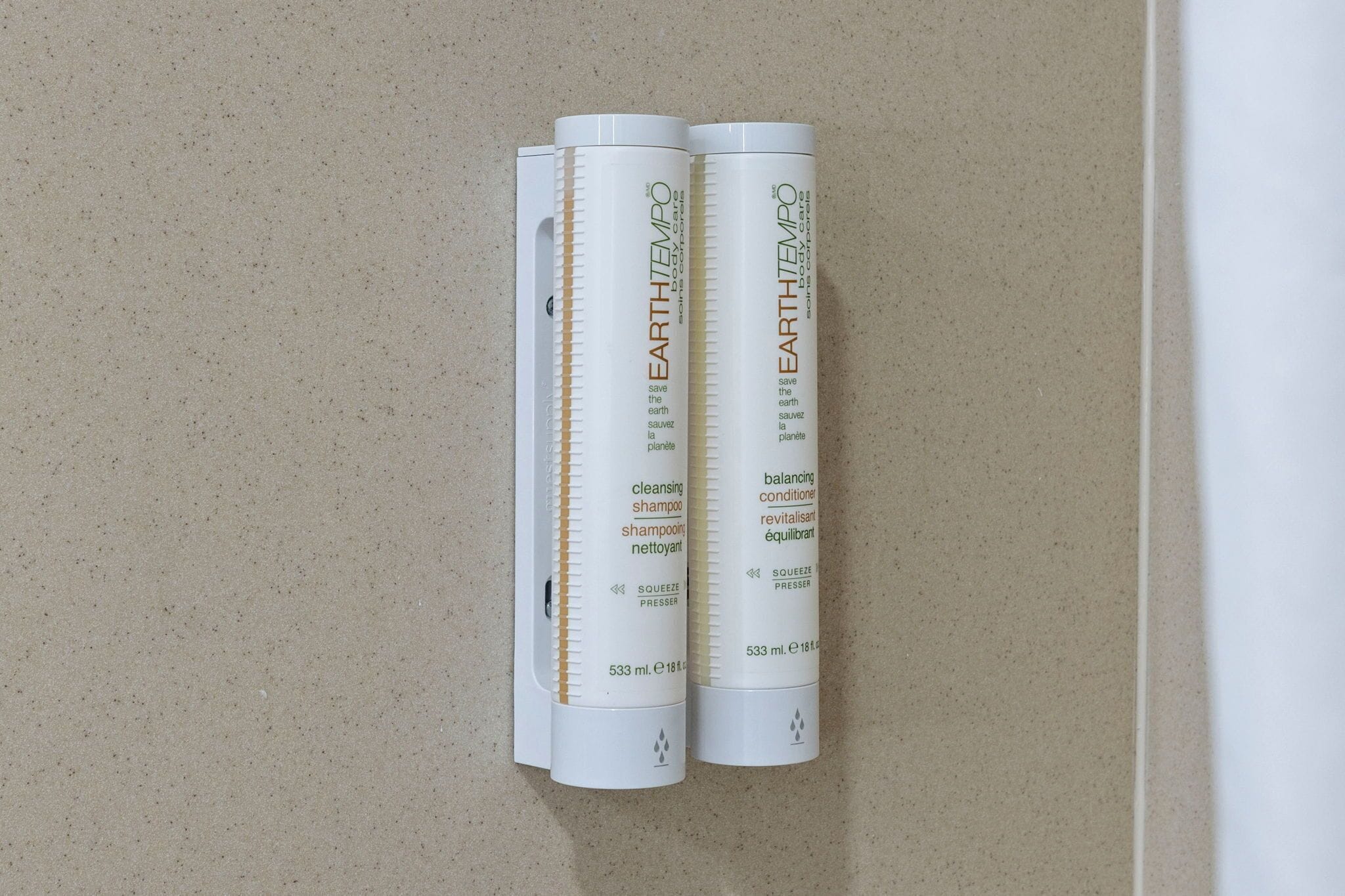 Two white cylindrical containers labeled 'EARTH TEMPO' on a speckled beige surface.
