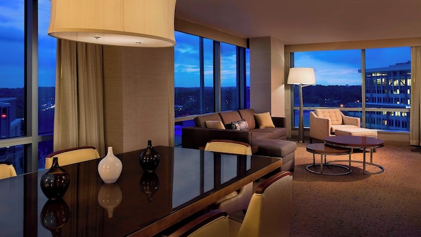 A modern hotel room with a large window, a dining table, a sofa, and a lamp. - The Westin Arlington (Arlington)