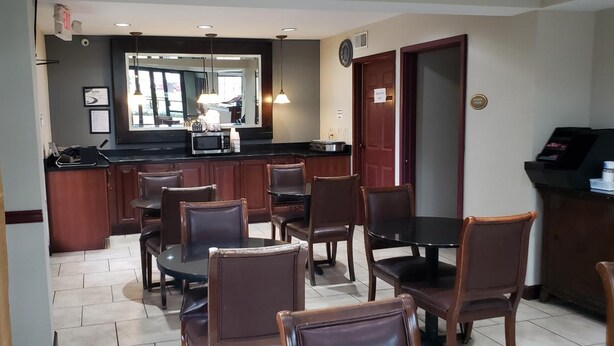 A hotel room with a dining area, a kitchen with a microwave, and a bar area. - Inn at Mulberry Grove (Port Wentworth)