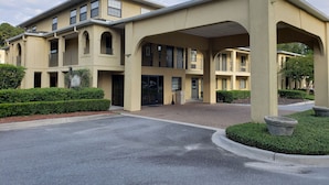 A multi-story hotel with a beige facade, arched balconies, and a covered entrance. - Inn at Mulberry Grove (Port Wentworth)