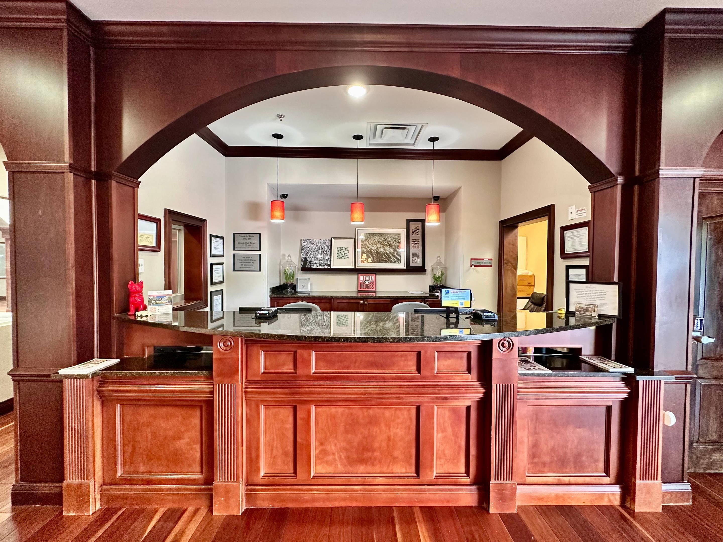 A reception area with a marble counter, wooden paneling, and framed certificates on the wall.