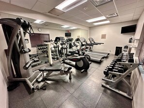 A gym with various exercise equipment, including treadmills, elliptical machines, and free weights.