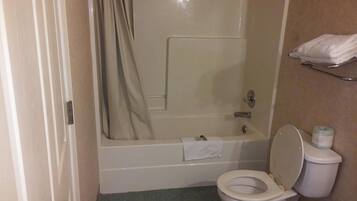 A bathroom with a bathtub, toilet, and a towel rack.
