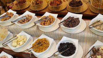 A buffet with various food items including nuts, dried fruits, and chocolate pieces.