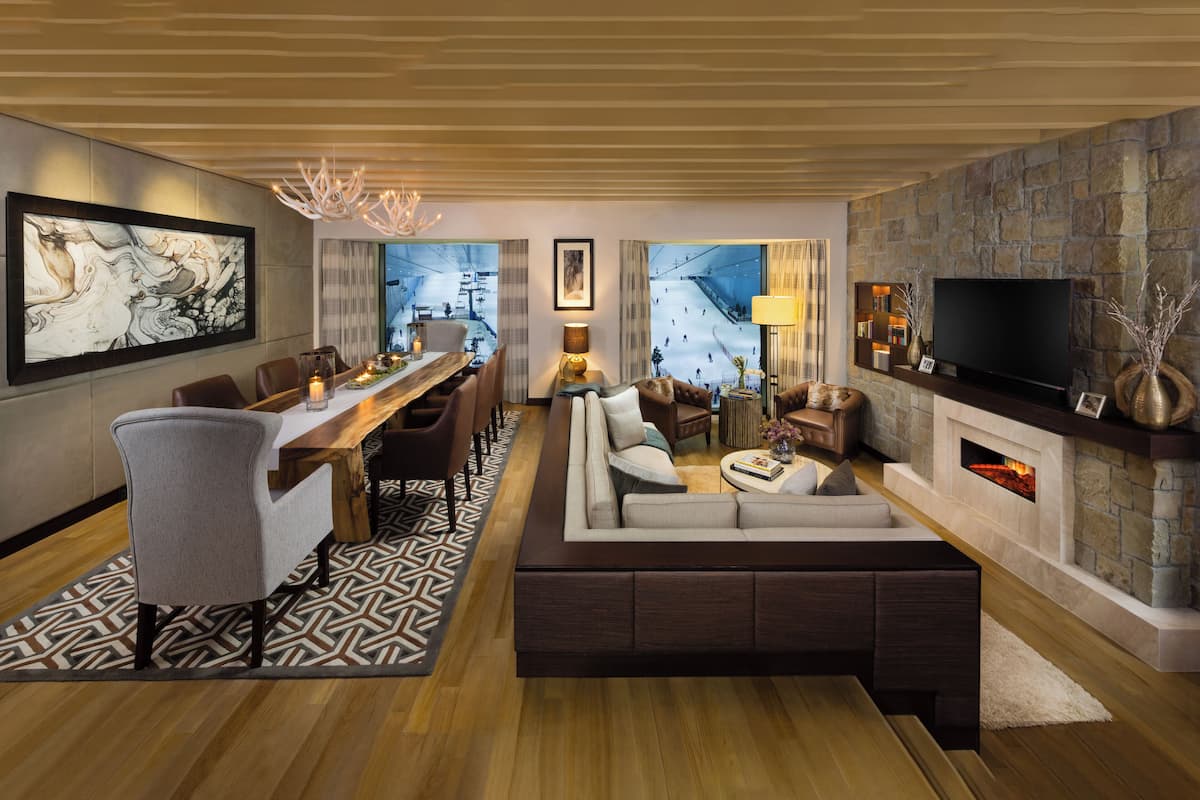 Un salon moderne comprenant un canapé, une table à manger et des chaises, une cheminée et un téléviseur.