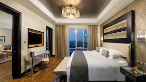 Una habitación de hotel moderna con una cama grande, un escritorio, un televisor y vistas a la ciudad.