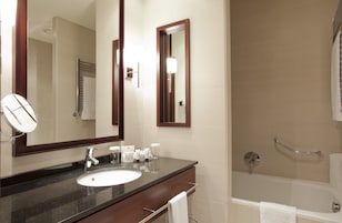 Une salle de bain avec un lavabo, un miroir et une baignoire.