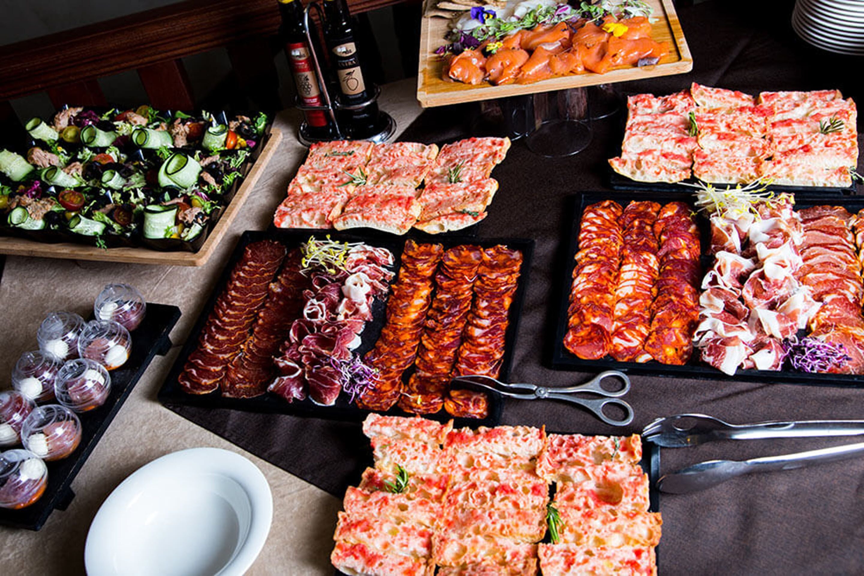Une variété d’aliments, notamment des viandes, des fromages et des salades, disposés sur une table.