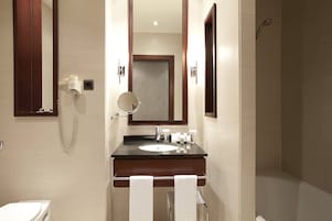 A modern bathroom with a sink, mirror, and shower.