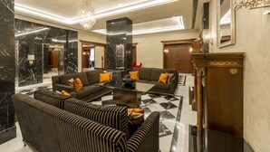 A modern lobby with black and white striped sofas, a glass coffee table, and a chandelier. - Hotel Barcelona Center (Barcelona)