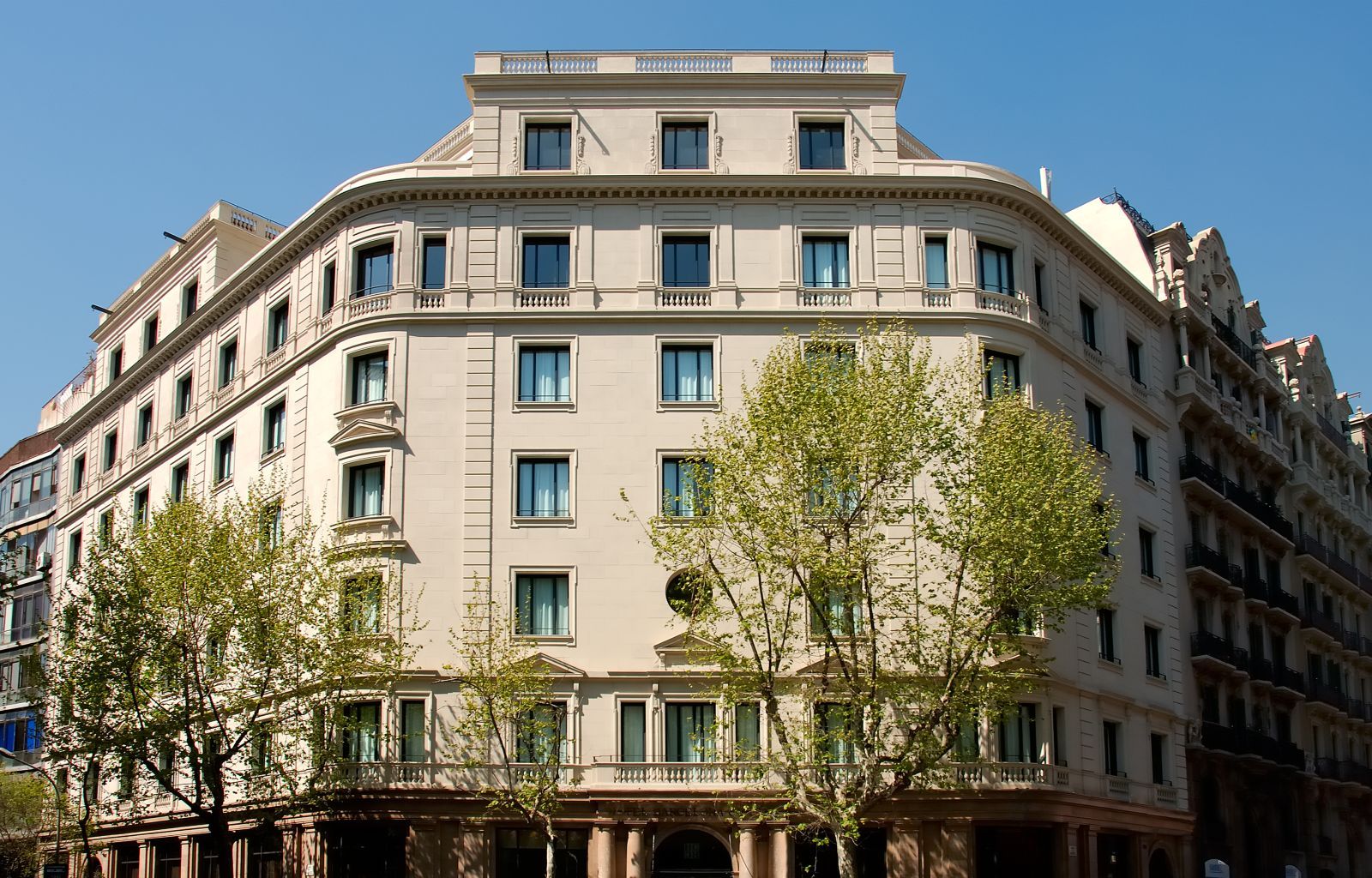 A multi-story building with a classical architectural style, featuring a symmetrical facade, numerous windows, and a central entrance with columns.