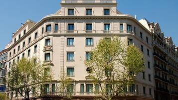 A multi-story building with a classical architectural style, featuring a symmetrical facade, numerous windows, and a central entrance with columns.