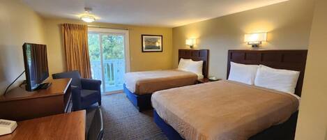 A hotel room with two beds, a desk, a chair, and a television.