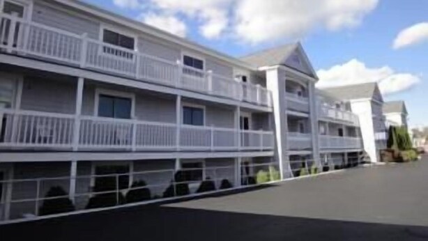 A multi-story hotel with balconies, a flat roof, and a clear sky. - Hyannis Travel Inn (Hyannis)