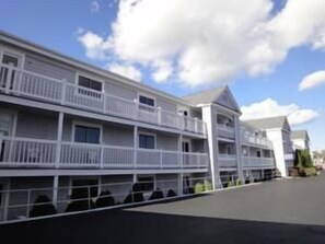 A multi-story hotel with balconies, a flat roof, and a clear sky. - Hyannis Travel Inn (Hyannis)