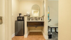 A compact bathroom with a coffee maker, a microwave, and a tiled backsplash. - Hotel Avenida Victorville I 15 (Victorville)