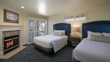 A hotel room with two beds, a fireplace, and a view of the outdoors.