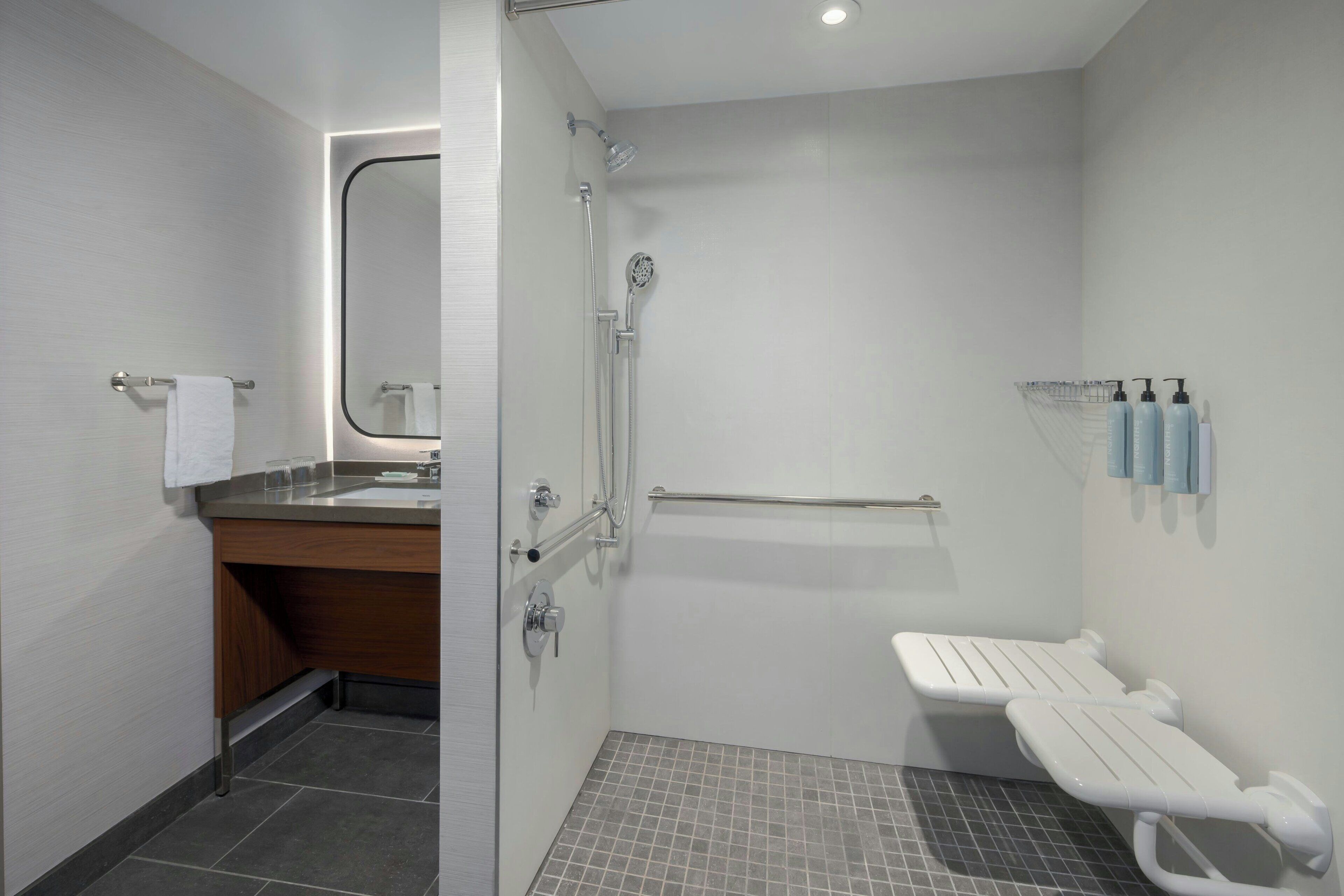 Een moderne badkamer met een douche, een wastafel en een toilet.