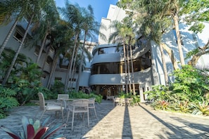 Un patio con mobiliario exterior y palmeras.