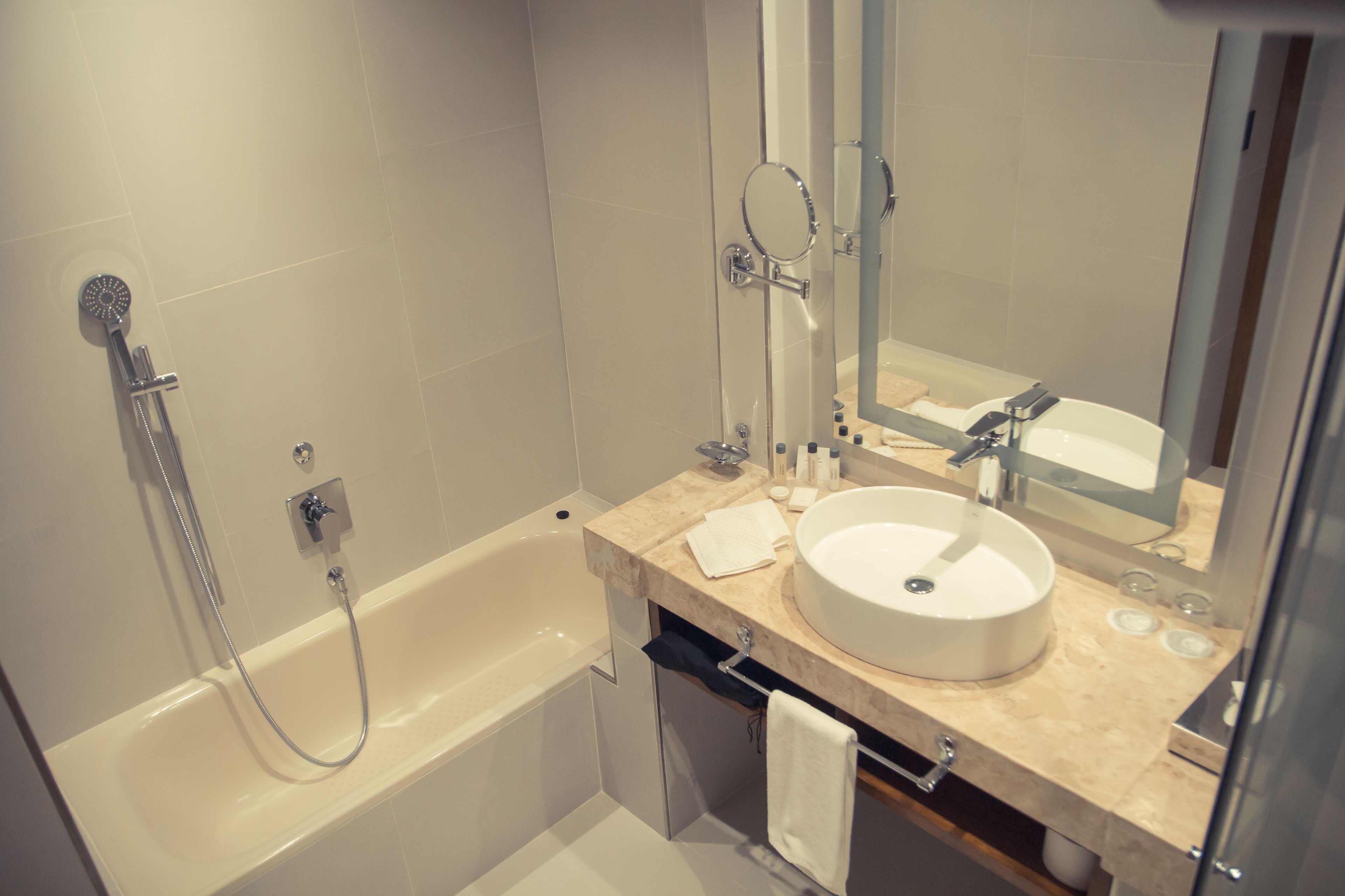 Un baño moderno con bañera, lavamanos y espejo.