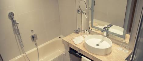 Un baño moderno con bañera, lavamanos y espejo.