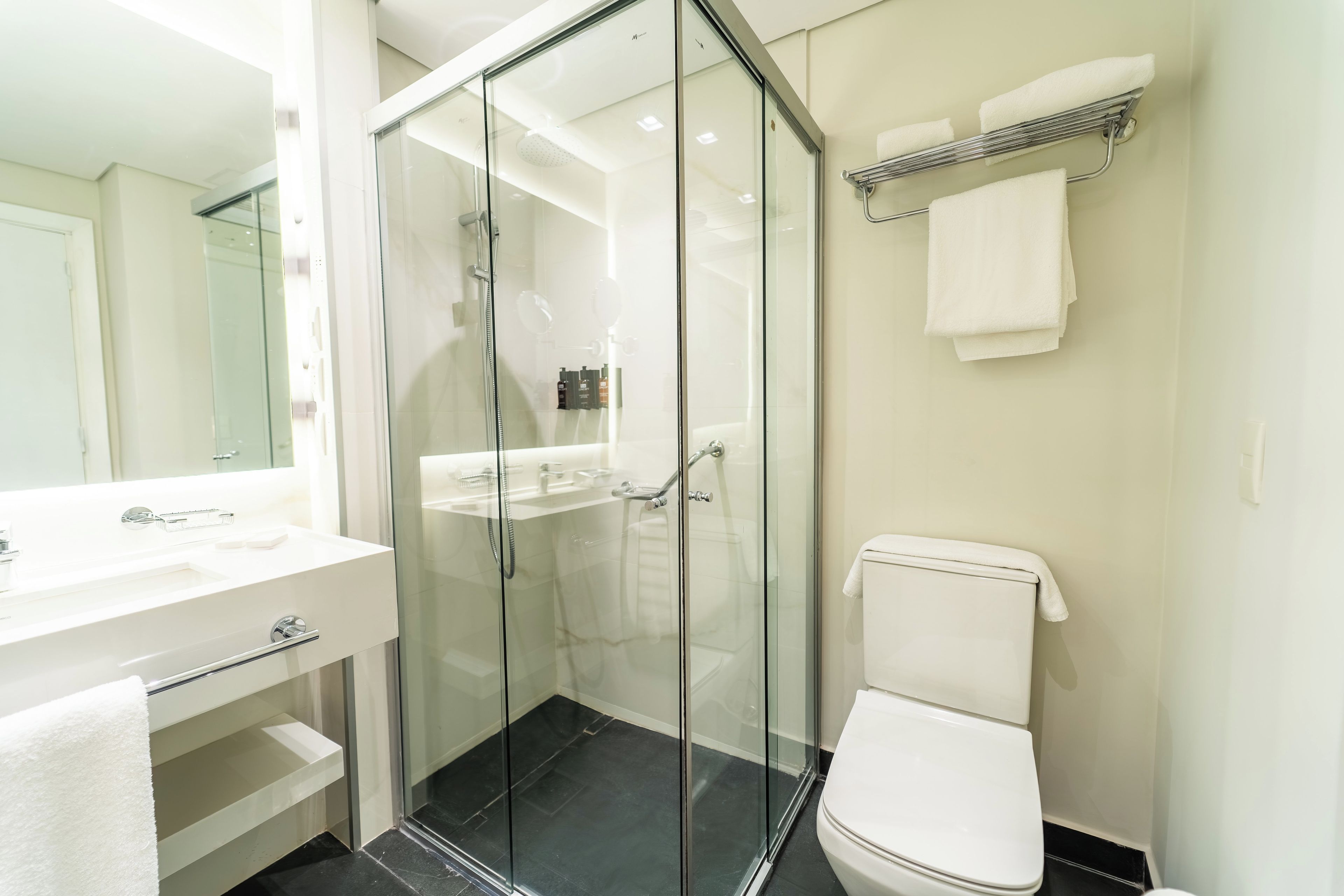 Ein modernes Badezimmer mit einer einteiligen Duschkabine, einem weißen Waschbecken und einer Toilette.