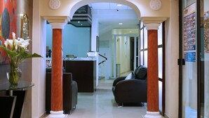 A hotel lobby with a chandelier, columns, a reception desk, and a seating area. - Best Western Taxco (Taxco)